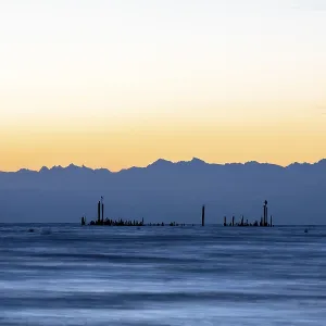Peaceful lake with mountains on the horizon at sunrise