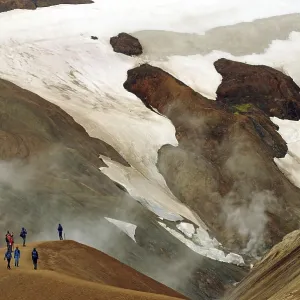 People on a hiking trail in front of snowfields