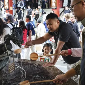People purify themselves at a purification well in Senso-ji Temple People purify themselves at a purification well in Senso-ji Temple