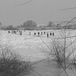 People walk across ice rink, frozen Elbe