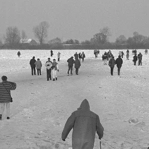 People walk across ice rink, frozen Elbe