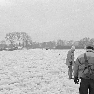 People walk across ice rink, frozen Elbe