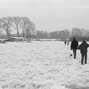 People walk across ice rink, frozen Elbe
