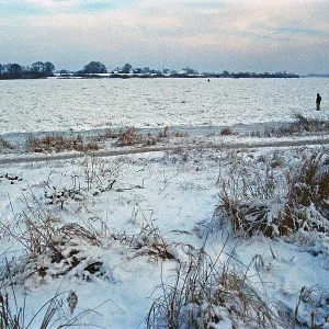 People walk across ice rink, frozen Elbe