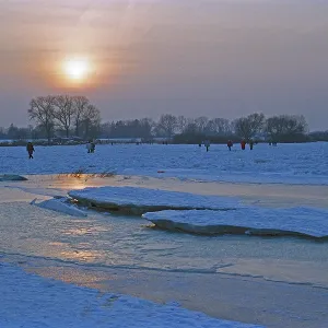 People walk across ice rink, sunset