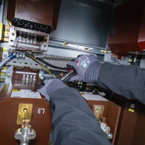 Person wearing gloves working on an electrical switch box