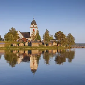 The picturesque old church of Raettvik surrounded by horse stables at Lake Siljan The picturesque old church of Raettvik surrounded by horse stables at Lake Siljan