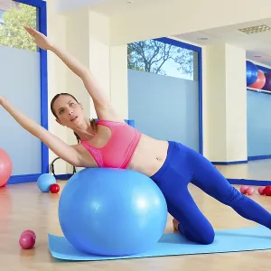 Pilates woman side bend fitball exercise workout at gym indoor swiss ball Pilates woman side bend fitball exercise workout at gym indoor swiss ball