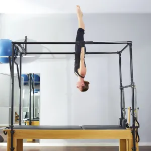 Pilates woman in cadillac acrobatic upside down balance reformer exercise at gym Pilates woman in cadillac acrobatic upside down balance reformer exercise at gym
