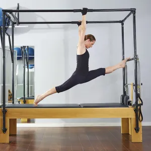 Pilates woman in cadillac legs split reformer exercise at gym Pilates woman in cadillac legs split reformer exercise at gym