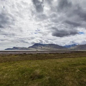 Plain and mountains of o fjord with an overcast sky on Iceland