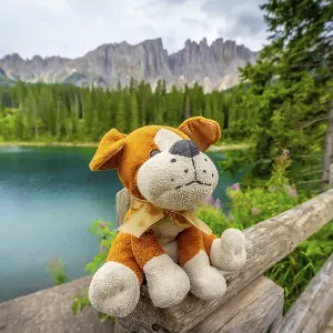 Plush dog sitting on a wooden fence