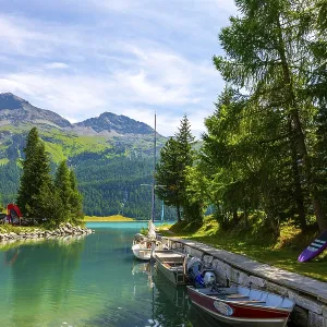 Port with Boat on the Beautiful Alpine Lake Silvaplana with Mountain View in the Swiss Alps in a Sunny Summer Day Port with Boat on the Beautiful Alpine Lake Silvaplana with Mountain View in the Swiss Alps in a Sunny Summer Day