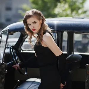 Portrait of beautiful sexy fashion girl model with bright makeup in retro style near vintage car
