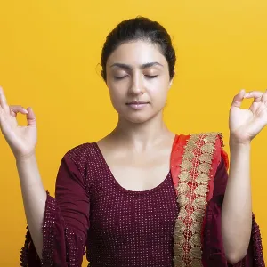 Portrait of young adult indian woman in sari meditate zen like with ok sign mudra gesture