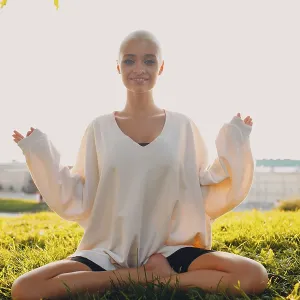 Portrait of young millenial european short haired woman doing yoga lotus asana on green grass meadow summer park sunset