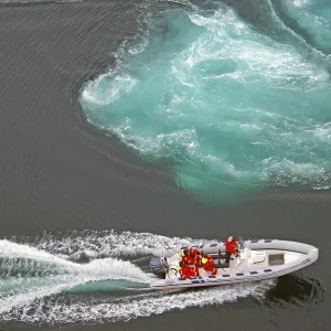 Powerboat with passengers between tidal eddies in the sea