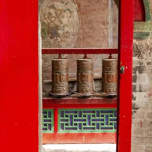 Prayer wheels behind a gate in a Tibetan temple of the Kumbum Jampaling monastery complex in Xining
