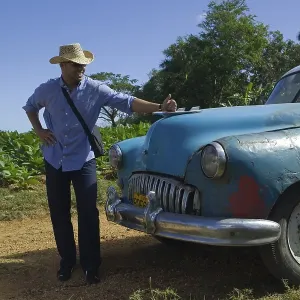 Proud owner, vintage car in Valle de Vinales Proud owner, vintage car in Valle de Vinales
