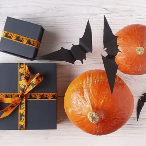 Pumpkin gifts black paper bats on light wood flat lay halloween decor Pumpkin gifts black paper bats on light wood flat lay halloween decor