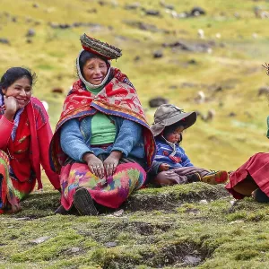 Quechua Indian family in traditional dress sitting in a meadow Quechua Indian family in traditional dress sitting in a meadow