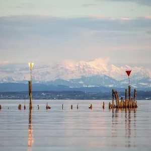 Quiet lake scene with distant mountains in the background and reflecting water under a blue sky Quiet lake scene with distant mountains in the background and reflecting water under a blue sky