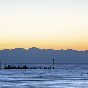 Quiet morning atmosphere over the lake with distant mountain silhouettes