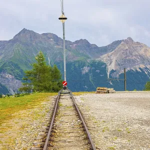 Railroad Tracks End Station with Mountain View Alp Gruem in Swiss Alps in a Cloudy Summer Day in Poschiavo