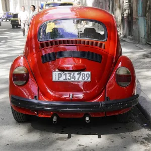 The rear view of a vintage red VW Beetle car on an urban road The rear view of a vintage red VW Beetle car on an urban road