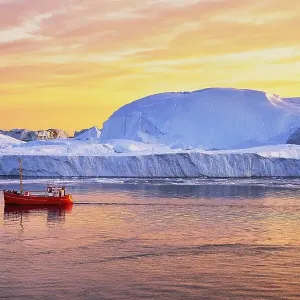 Red boat with tourists in front of icebergs in evening light Red boat with tourists in front of icebergs in evening light