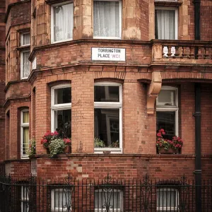Red brick building with flower boxes on windows in the city in Greater London Red brick building with flower boxes on windows in the city in Greater London