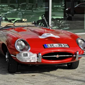 A red classic convertible classic car stands on a paved square A red classic convertible classic car stands on a paved square