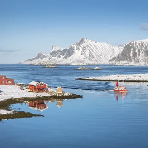 Red farmhouse and fishing boat are reflected in the fjord Rossoy Straumen