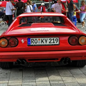Red Ferrari sports car seen from behind among other classic cars Red Ferrari sports car seen from behind among other classic cars