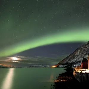 Red fishing huts on the fjord in winter with Northern Lights Red fishing huts on the fjord in winter with Northern Lights