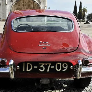 Red Jaguar E-Type classic car from behind in a square