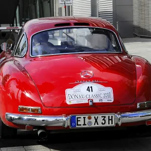 Red Mercedes classic car with Donau Classic 2011 license plate in urban area Red Mercedes classic car with Donau Classic 2011 license plate in urban area