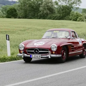 Red Mercedes vintage car on country road with green landscape Red Mercedes vintage car on country road with green landscape