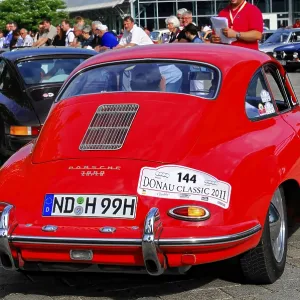 Red Porsche with audience in the urban setting of a classic car event