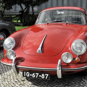 Red Porsche classic car seen from the front on a cobblestone