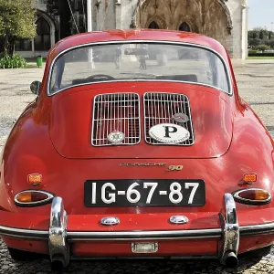 Red Porsche classic car seen from behind in a square