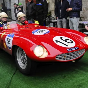 Red racing barchetta with start number 16 glides across the green carpet Red racing barchetta with start number 16 glides across the green carpet
