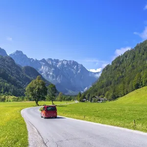 Red van driving along a winding road in the picturesque logarska dolina valley Red van driving along a winding road in the picturesque logarska dolina valley