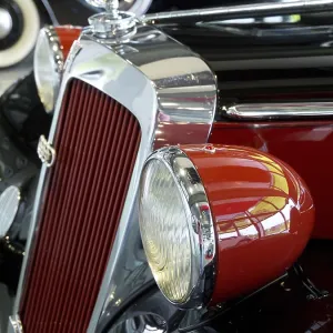 Red vintage car with round headlights and retro-style chrome details