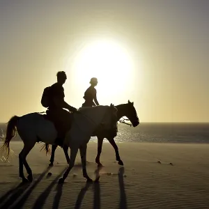 Two riders on horseback on the beach