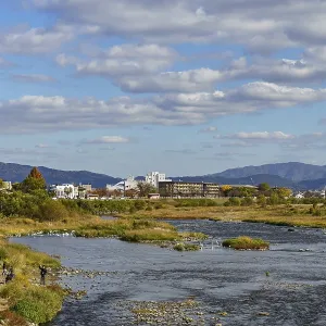 A river landscape with an urban background and picturesque mountains A river landscape with an urban background and picturesque mountains