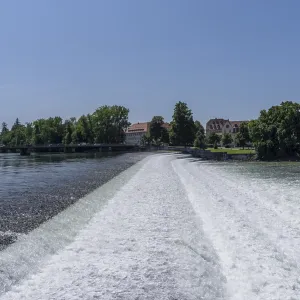 River Lech flowing over a weir with old town architecture under a clear blue sky River Lech flowing over a weir with old town architecture under a clear blue sky