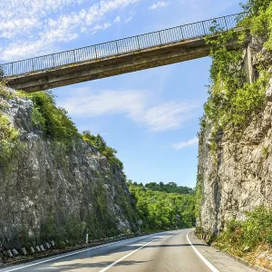 Road through mountains under connecting bridge in Montenegro Road through mountains under connecting bridge in Montenegro