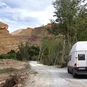 Road with a vehicle leads through the impressive scenery of the Dades Gorge