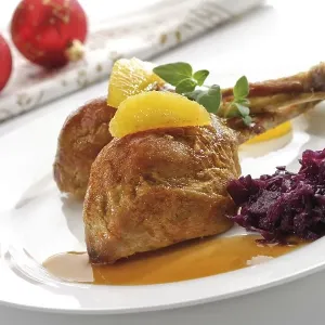 Roast chicken legs or drumsticks garnished with two orange segments